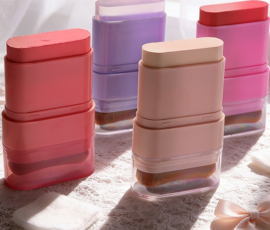 Multiple pastel‑toned retractable blush brush makeup cases arranged on lace tablecloth